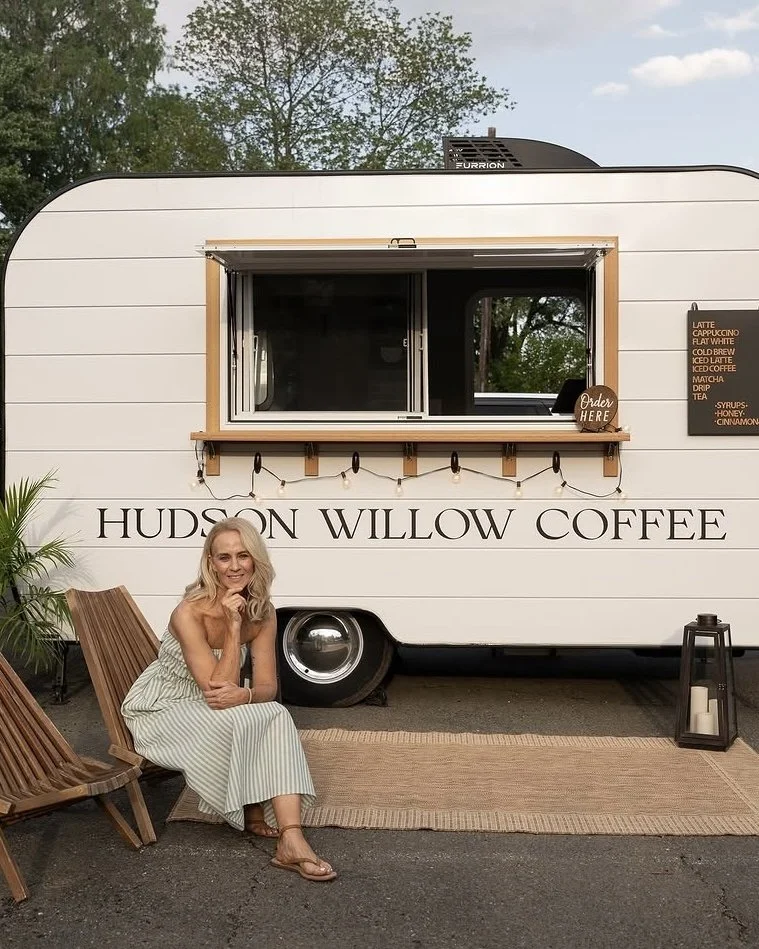 Hudson Willow Coffee owner seated beside her white mobile coffee trailer