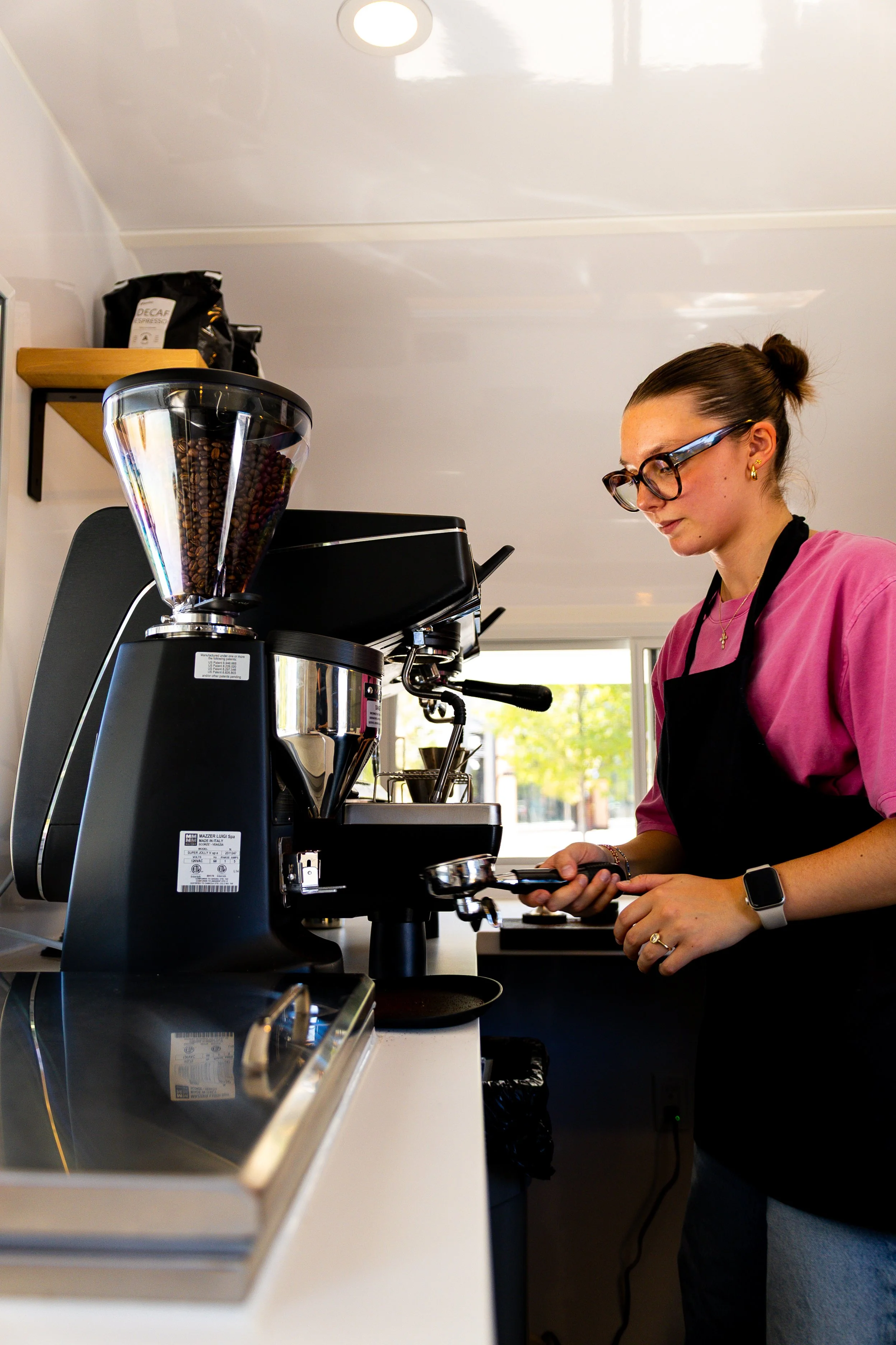 Prickly Pear Coffee Co. barista operating an espresso machine inside the trailer